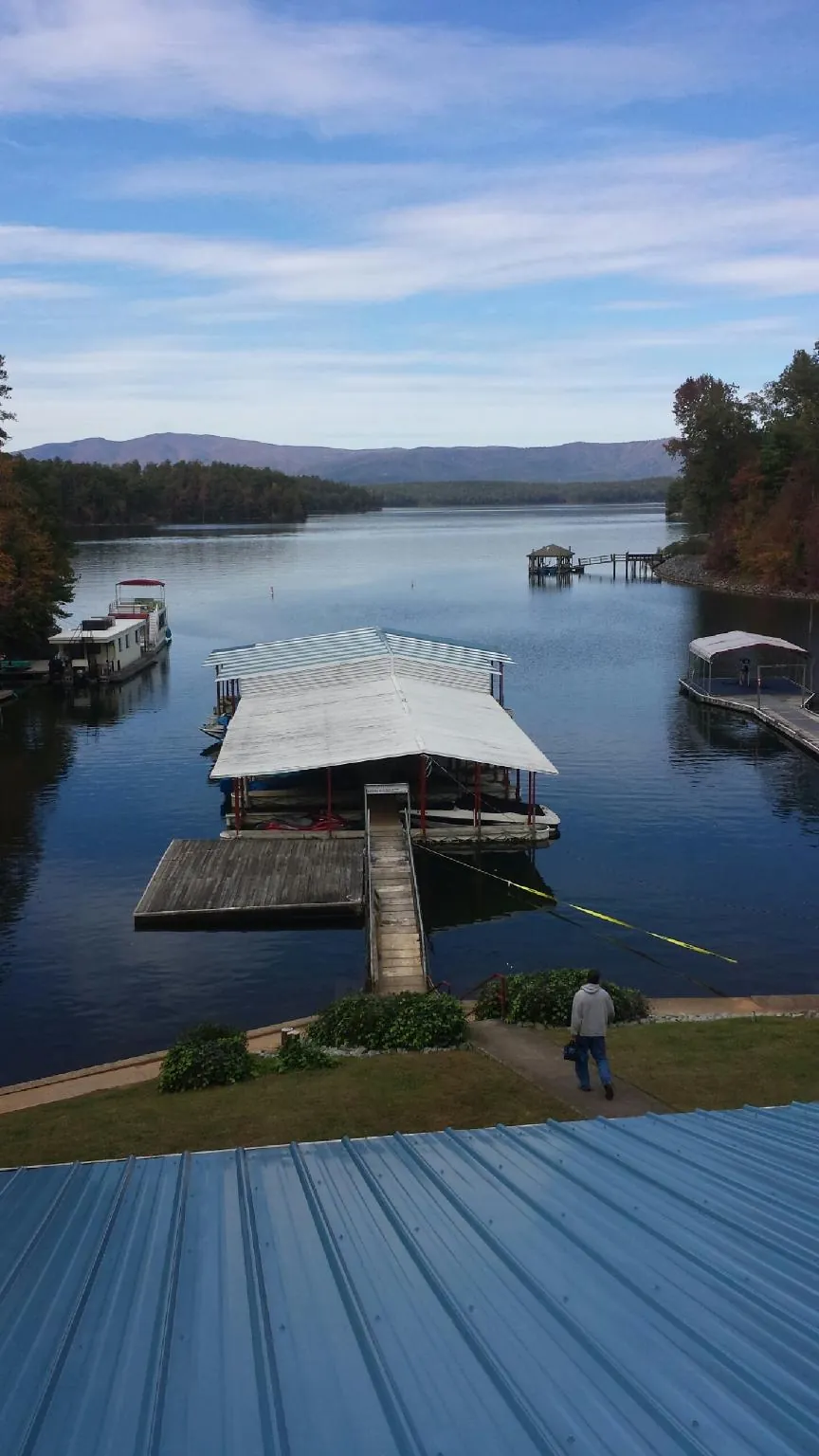 View across a lake from a newly installed blue metal roof in Breezy Point