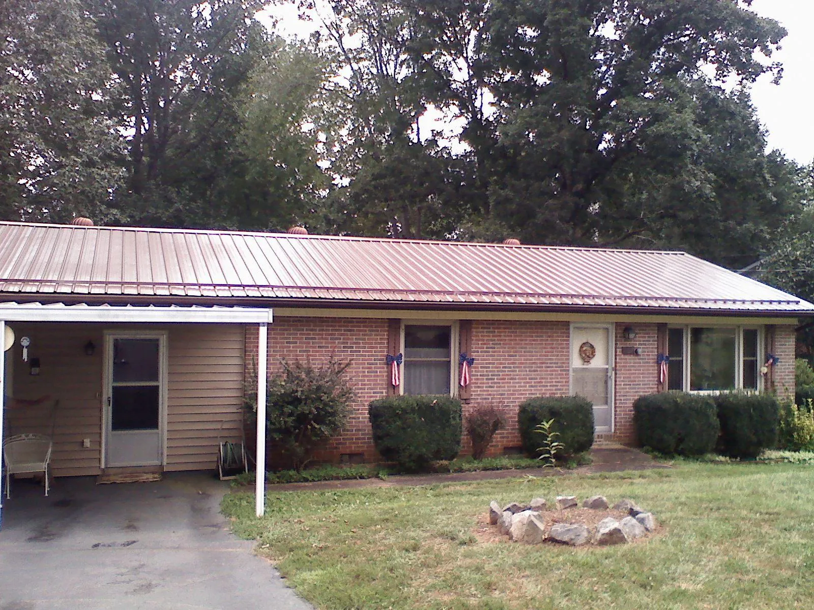 Bronze metal roof and carport on a brick ranch home — Roof Repair work by our crew in Breezy Point