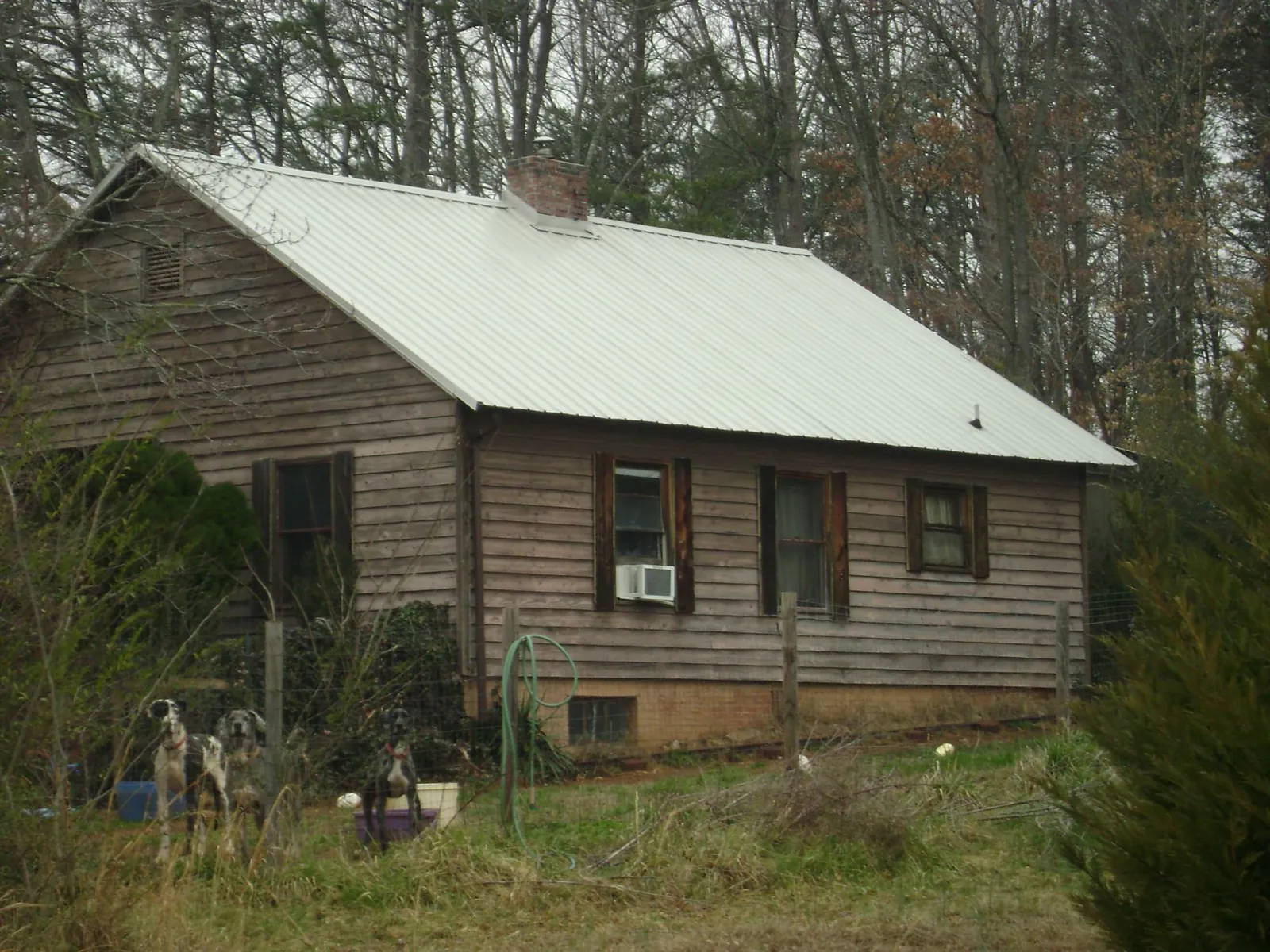 White metal roof on an old wood sided farmhouse, from a Metal Roof Installation job in Breezy Point